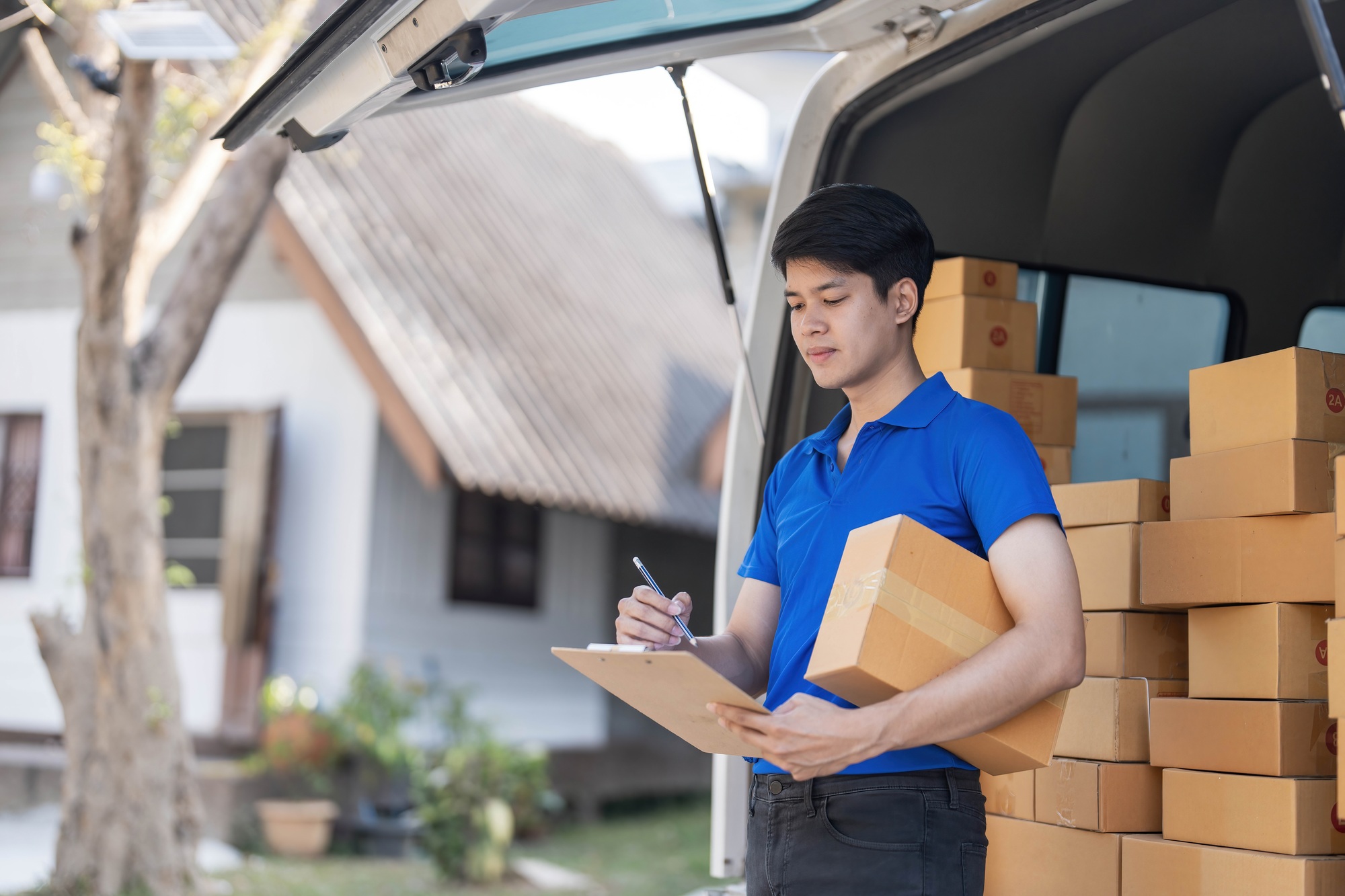 Asian courier with parcel and delivery logistic concept. Delivery man with checking list on